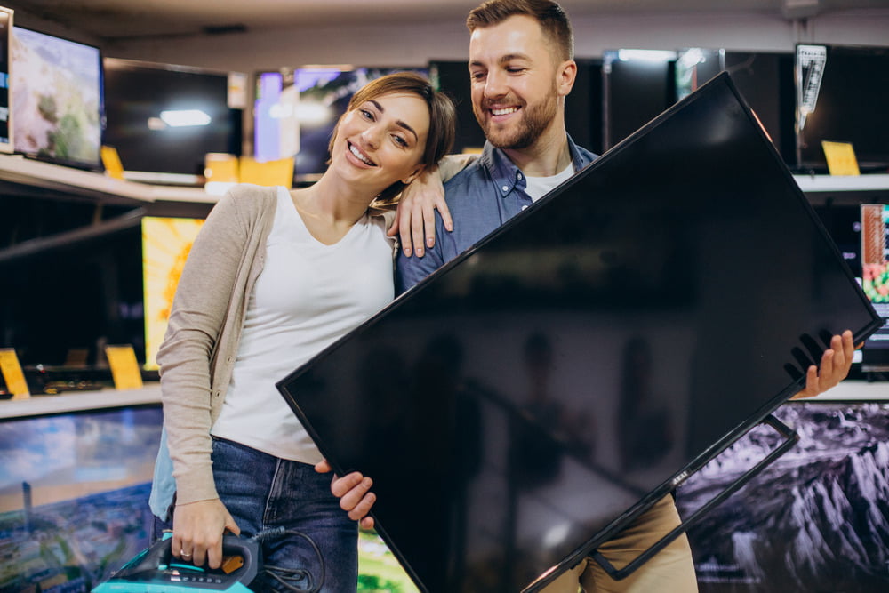 Happy couple buying a TV at a pawn shop