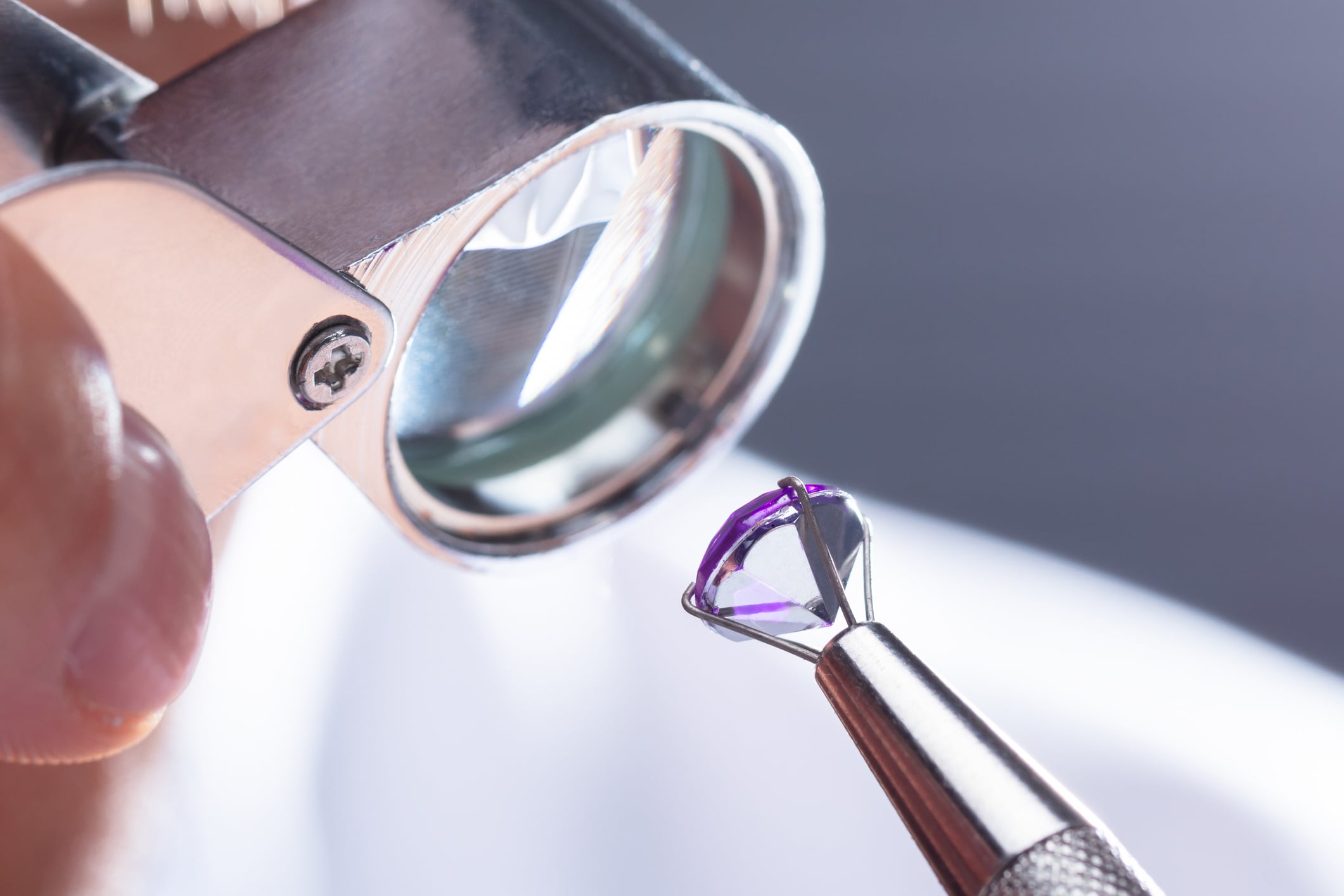 Jeweler Looking At Diamond Through Magnifying Loupe